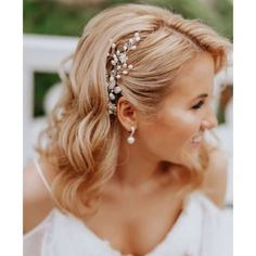 a woman with blonde hair wearing a white dress and pearls in her hair is smiling at the camera