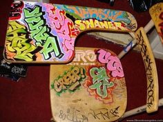 three wooden skateboards covered in graffiti sitting on top of a red carpeted floor