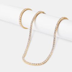 Elevate your everyday elegance with the exclusive "Jewels Essence 20" Diamond Tennis Chain Necklace." Available in the warm hue of gold or the timeless luster of silver, this quintessential piece is designed to add a touch of luxury to your personal collection. Each necklace is meticulously set with a single row of brilliant-cut diamonds, selected for their exceptional clarity and radiance. The fluidity of its design ensures it drapes gracefully, making it a versatile accessory suitable for both day and evening wear. The seamless cascade of sparkle it provides is sure to turn heads and elevate any ensemble. The resplendent sparkle is set against your choice of rich gold or sleek silver, creating an alluring contrast that catches both the light and the gaze of onlookers. Each diamond is per Gold Luxury Tennis Necklace, Gold Diamond Chain Necklace For Everyday Luxury, Dazzling Gold Cubic Zirconia Chain Necklace, Gold Diamond Tennis Necklace With Box Chain, Classic Gold Tennis Necklace With Adjustable Chain, Gold Crystal Necklace Fine Jewelry, Dazzling Gold Necklace, Classic Gold Chain Necklace With Diamond Accents, Gold Round Tennis Necklace For Gift