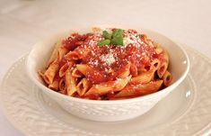 a white bowl filled with pasta and sauce