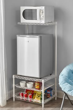 a microwave oven sitting on top of a metal shelf next to a chair and table