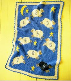 a crocheted blanket with sheep and stars on it