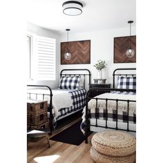 two beds in a bedroom with plaid comforters