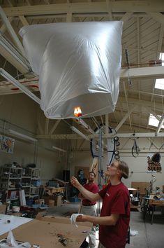 two men working on something in a large room