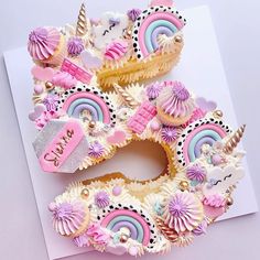 the letter e made out of cupcakes is decorated with unicorns and rainbows