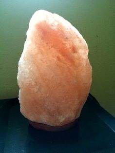 a large rock sitting on top of a table next to a green wall with the words, drying out a sweating salt lamp