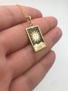 Elevate your style with our exquisite Sun Tarot Card Necklace, a captivating piece crafted in radiant 14K gold. The celestial charm of this necklace is accentuated by a delicately engraved rectangular pendant, making a bold statement in the realm of spiritual jewelry. This unique accessory not only serves as a fashionable adornment but also holds profound symbolic significance. Embrace the celestial energy and channel the sun's vibrant power with this stunning piece, making it an ideal gift for Celestial Rectangular Pendant Jewelry Gift, Symbolic Rectangular Jewelry For Anniversary, Celestial Style Rectangular Pendant Jewelry Gift, Spiritual Engraved Rectangular Jewelry, Handmade Yellow Gold Rectangular Jewelry, Handmade Rectangular Yellow Gold Jewelry, Gold Rectangular Spiritual Jewelry, Symbolic Rectangular Pendant Jewelry As Gift, Symbolic Rectangular Pendant Jewelry For Gifts