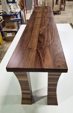 a wooden bench sitting on top of a white table