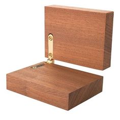 a wooden box with a brass hinge on the top and bottom, open to reveal a piece of wood that has been cut in half