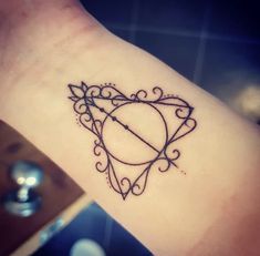 a heart shaped tattoo with an arrow in the middle on someone's arm,