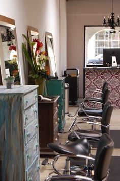 a row of chairs sitting next to each other in front of a dresser and mirror