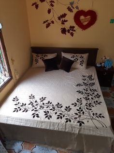 a bed with white sheets and black pillows