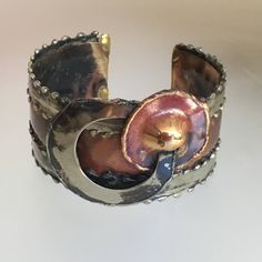 "This phenomenal bracelet was likely an artisan piece made in the 1980s. It is fabricated of copper and pewter, and the unique design makes such incredible impact! A true one-of-a- kind statement piece! SPECIFICS: Width: 1.25\" Weight: 43.4 grams Interior Circumference: 7.25\" including 1\" gap Excellent Condition Unsigned" Artistic Gold Copper Bracelets, Artisan Metal Cuff Bangle Bracelet, Bronze Metal Bracelet With Patina, Hand Cast Bronze Metal Cuff Bracelet, Hand Forged Bronze Metal Bracelets, Unique Bronze Metal Cuff Bracelet, Handmade Brass Cuff Bracelet Collectible, Unique Metal Cuff Bracelet Collectible, Unique Hand Forged Cuff Bracelet