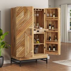 a wooden cabinet with wine glasses and bottles in it next to a potted plant