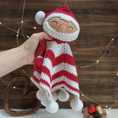 a crocheted santa clause doll hanging from a string