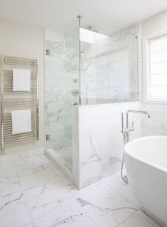 a bathroom with marble floors and white walls, along with a large bathtub in the corner