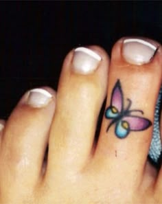 a close up of a person's foot with a butterfly tattoo on their toe