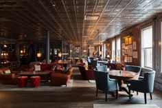 an empty restaurant with lots of chairs and tables in the center, along with large windows