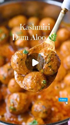 a ladle filled with meatballs and sauce on top of a wooden spoon in front of the words kashmii dum aloo