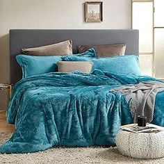 the bed is made with blue comforters and pillows