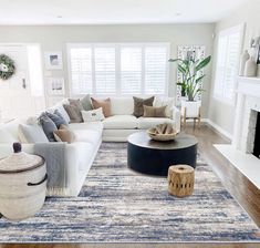 a living room filled with furniture and a large rug on top of a hard wood floor