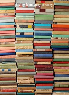 a large stack of books sitting on top of a wooden floor next to each other