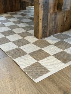 a checkered rug is on the floor next to a wooden bench