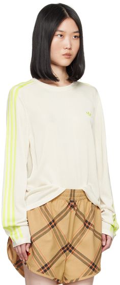 Knit rayon- and recycled polyester-blend T-shirt. · Rib knit crewneck, hem, and cuffs · Logo embroidered at chest and back collar · Intarsia stripes at sleeves Part of the Wales Bonner x adidas Originals collaboration. Supplier color: Chalk white/Semi frozen yellow Sporty Spring Sweater With Embroidered Logo, Athleisure Crew Neck T-shirt With Ribbed Cuffs, Sporty Crew Neck T-shirt With Ribbed Collar, Sporty T-shirt With Ribbed Collar And Crew Neck, Sporty T-shirt With Ribbed Crew Neck, Sporty Crew Neck Sweater With Embroidered Logo, Athleisure Crew Neck Top With Embroidered Logo, Athleisure Tops With Embroidered Logo, Sporty Crew Neck Top With Three Stripes