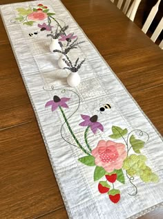 a table runner with flowers and bees on it