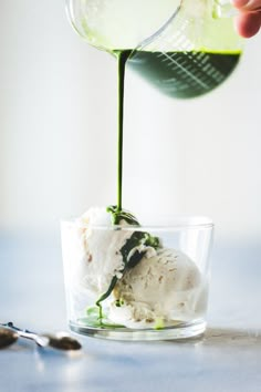 someone pouring ice cream into a glass cup