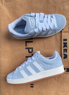 De Adidas Campus 00s 'Blue Grey' (IH7509). De Adidas Campus sneaker werd oorspronkelijk ontworpen voor basketballers in de jaren 80, maar werd later vooral populair onder skateboarders. Met deze vernieuwde versie geïnspireerd op het silhouet rechtstreeks uit de jaren 2000 heeft Adidas een hit te pakken! De Campus 00s hebben een lage platformstructuur. Het suède bovenwerk met de licht blauwe kleur en brede veters maken dit 'de sneaker' van dit jaar. Pretty Sneakers, Preppy Shoes, All Nike Shoes, Shoes Outfit Fashion, Cute Nike Shoes