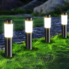 three solar powered lights in the grass