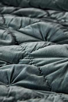 close up view of an unmade bed with black quilting on the top and bottom