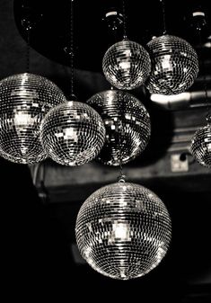 disco balls hanging from the ceiling in black and white