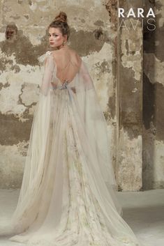 the back of a woman's wedding dress with an open - back and long veil