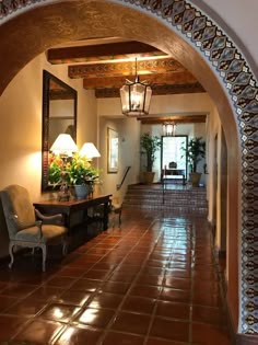 an archway leading to a living room filled with furniture and lamps on either side of the hallway