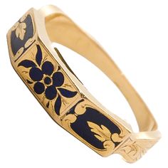 This antique Victorian memory ring is a finely crafted piece, designed in 18-karat gold and adorned with intricate black enamel. The enamel is decorated with a delicate floral design, featuring a "forget-me-not" flower motif. This flower, often associated with remembrance and enduring love, was a popular symbol in Victorian jewelry, adding sentimental and symbolic value to the piece. The outer band of the ring is richly decorated with black enamel, which provides a striking contrast to the warm glow of the gold. The centerpiece of the design is the forget-me-not flower, beautifully rendered in enamel, with its delicate petals symbolizing love, remembrance, and fidelity. The floral design gives the ring a timeless elegance, making it not only a piece of jewelry but also a sentimental keepsa Antique Engraved Yellow Gold Enamel Ring, Heirloom Engraved Enamel Ring For Wedding, Heirloom Engraved Enamel Wedding Ring, Heirloom Style Engraved Enamel Wedding Ring, Victorian Gold Enamel Ceremonial Ring, Gold Art Nouveau Jewelry With Intaglio, Heirloom Gold Enamel Ring, Gold Heirloom Enamel Ring For Formal Occasions, Heirloom Yellow Gold Engraved Enamel Ring