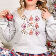 Get into the holiday spirit with our Groovy Santa Pink Christmas and Holiday Drink T-Shirt, Sweatshirt, or Hoodie. Featuring a groovy Santa and festive holiday drink design, this top is perfect for adding some fun to your wardrobe. Available in three styles - t-shirt, sweatshirt or hoodie - you can choose the fit that suits you best. Spread some cheer this season with our Groovy Santa Pink Christmas and Holiday Drink top. Key Features: - Festive Groovy Santa design - Fun holiday drink graphic - Available in t-shirt, sweatshirt or hoodie styles  Whether you're looking for a cozy sweatshirt to snuggle up in on cold winter nights or a casual t-shirt that expresses your festive spirit at any time of day, we've got you covered. The pink color adds an extra touch of whimsy to this jolly design. Cozy Crew Neck Sweater For Holiday, Cozy Winter Holiday Tops, Casual Holiday Hoodie With Crew Neck, Casual Crew Neck Hoodie For Holiday, Casual Christmas Hoodie With Crew Neck, Cozy Winter Holiday Sweatshirt, Casual Long Sleeve Hoodie For Holiday, Casual Long Sleeve Holiday Hoodie, Cozy Christmas Sweatshirt With Relaxed Fit