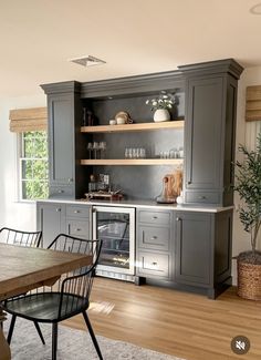 a dining room table and chairs in front of gray cabinets