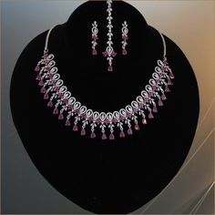 American diamond CZ Green,white and ruby stone studded rhodium plated bridal jewelry. Indian Bollywood style AD necklace, earrings and Tikka makes makes the perfect gifts for bridesmaids,Wife, Mother, Sister or Gift for Loved ones. Total length of the necklace + length of the extender is 17 inches. Length of Earring is 1.5 inches. Best suitable for Party Wear / Fashion Wear for Any Occasion. Care Instructions: We recommend avoiding direct exposure to fragrances. Silver Ruby Bridal Necklace Fine Jewelry, Silver Ruby Bridal Necklace In Fine Jewelry Style, Pink American Diamond Jewelry For Wedding, Elegant Ruby Jewelry Sets In Pink, Elegant Pink Ruby Jewelry Sets, Elegant Silver Ruby Jewelry Sets, Silver Bridal Necklace With Round Ruby, Silver Ruby Bridal Necklace, Round Shape, Silver Bridal Necklace With Ruby Accents