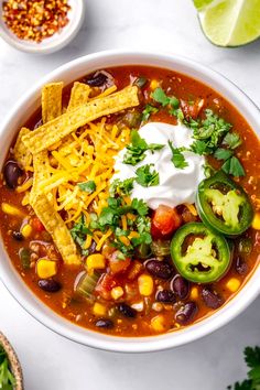 a white bowl filled with mexican soup and tortilla chips