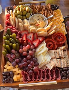 a platter filled with cheese, crackers, olives, and other snacks