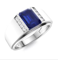 a white gold ring with a blue sapphire and diamonds on the sides, set in 18k white gold