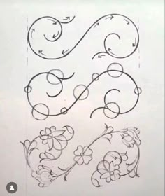 some type of drawing on paper with flowers and swirls in the middle, one is drawn