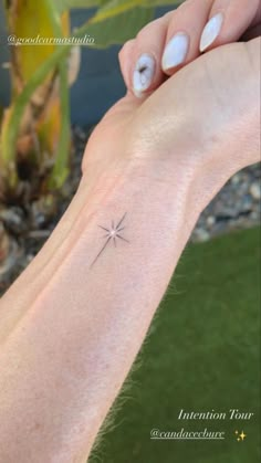 a woman's arm with a small star tattoo on the left side of her wrist