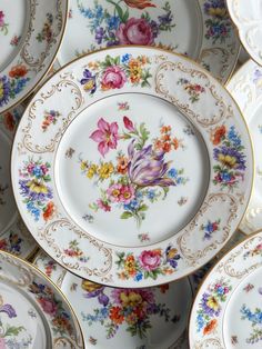 many plates with flowers painted on them are stacked up in the same pattern as each other