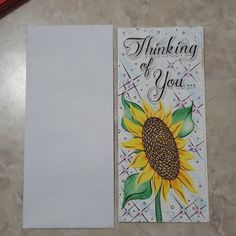 a card with an image of a sunflower and the words thinking of you on it