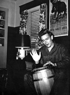 a man sitting on a couch playing a drum