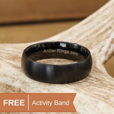 a black ring sitting on top of a piece of wood with the text free activity band