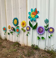 colorful flowers are painted on the side of a white fence